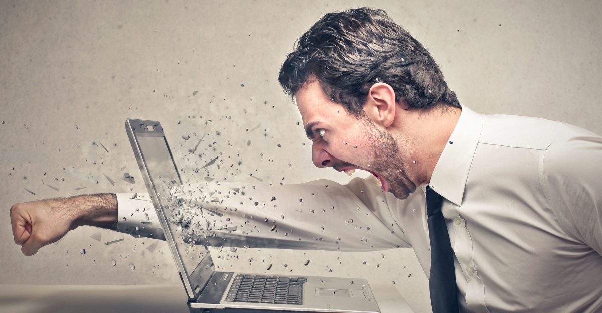 man smashes laptop