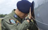 An Indonesian Navy airman prays next to his plane before a search flight.