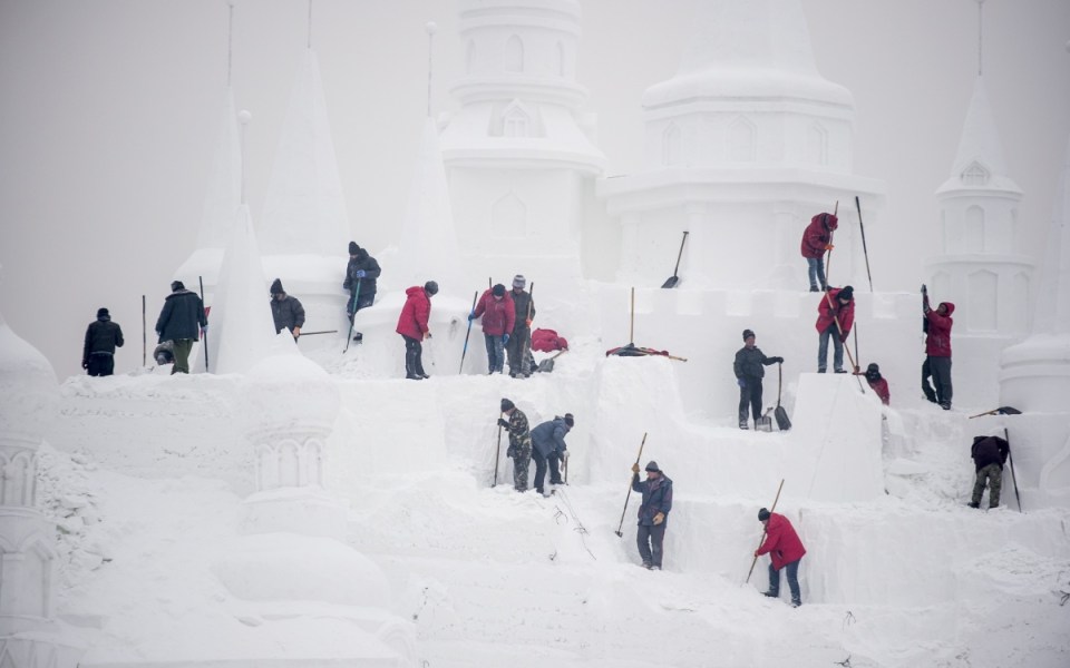 Ice sculptors carve a snow sculpture, on January 4, 2015 at the China Ice and Snow World on the eve of the opening ceremony of the 16th Harbin International Ice and Snow Festival