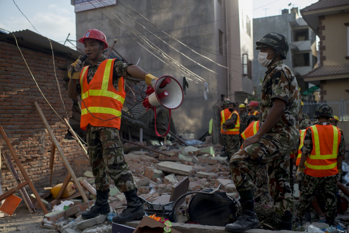 Nepalese Army work to dig up a little boy believed to be in the rubble of a house that collapsed.