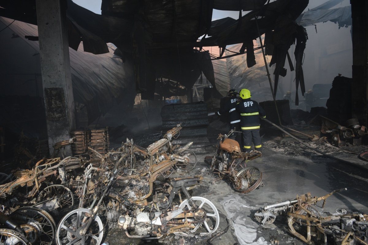 Firemen put out a fire after it gutted a footwear factory in Manila.