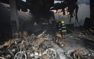 Firemen put out a fire after it gutted a footwear factory in Manila.