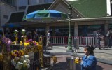 A woman pays her respects at the Erawan shrine.