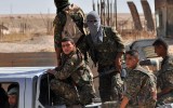 Kurdish People's Protection Units (YPG) fighter drives through Hasakeh.