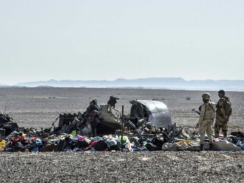 Egyptian soldiers stand guard next to debris and belongings of passengers of the plane.