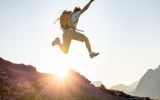 backpacker man sun jump happy
