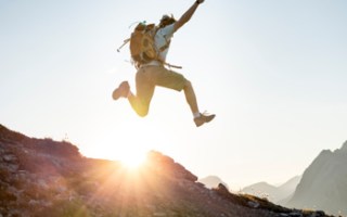 backpacker man sun jump happy