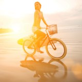 female cyclist no helmet beach