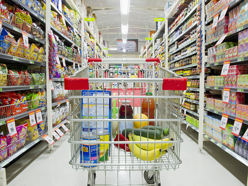 Shopping cart in grocery store aisle. trolley