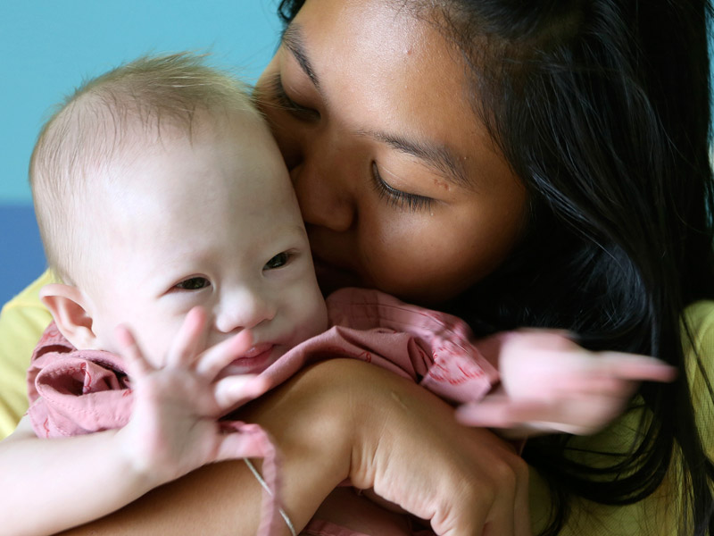 Surrogate Pattaramon Chanbua kisses baby Gammy at a hospital in Chonburi province, southeastern Thailand.