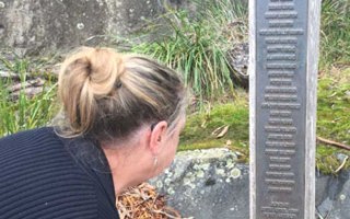Lynne Beavis reads the names on the memorial commemorating the 35 people who were killed.