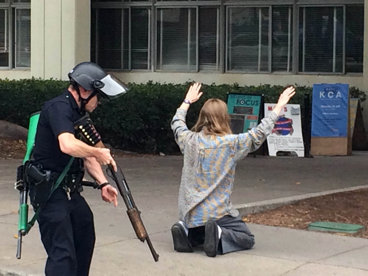 A SWAT officer searches a student who was evacuated from the UCLA campus