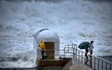 A fisherman braves the wild weather lashing the coast at Merewether.