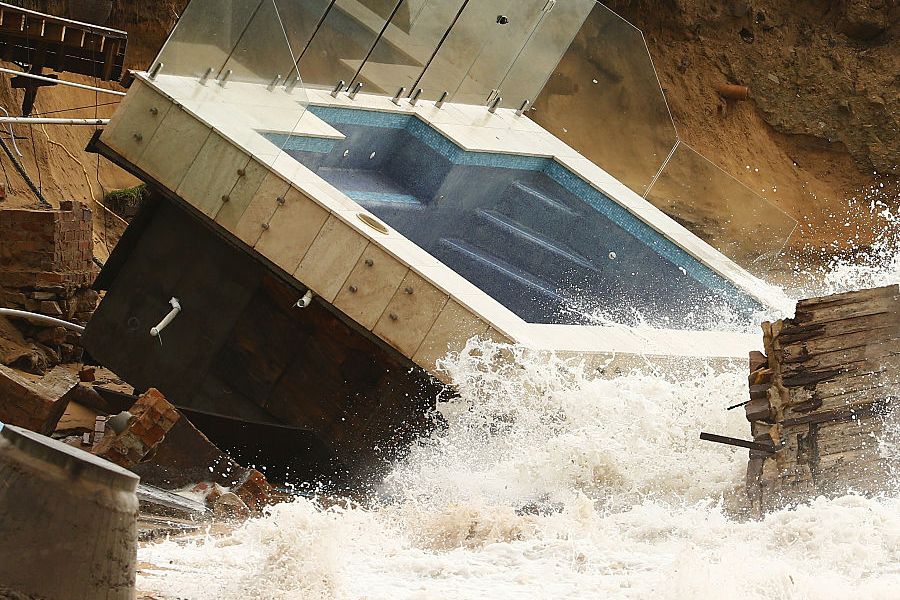A destroyed pool is hit by big waves after torrential rains.