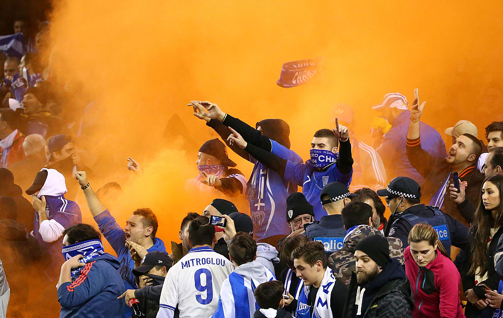 Fans ignite flares during the friendly between the Socceroos and Greece last night.