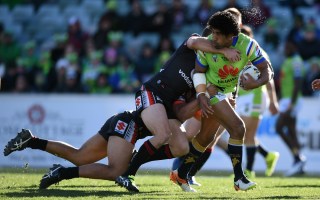 Iosia Soliola of the Raiders is tackled by Simon Mannering, and Bunty Afoa of the Warriors at GIO Stadium