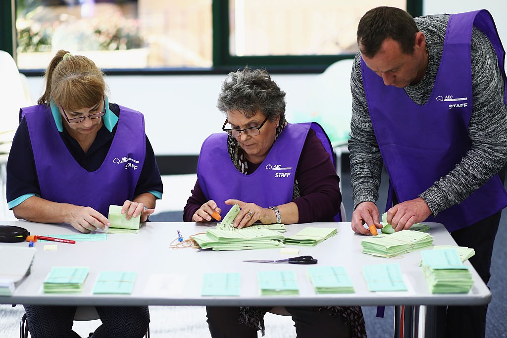 Scrutineers count postal votes at the Gordon counting centre.
