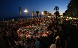 People gather at a makeshift memorial on the Promenade des Anglais in Nice.
