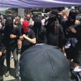 Protesters covered their faces as they stood in front of police.