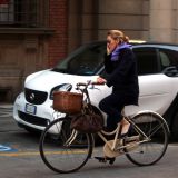 A woman talks on her mobile phone while cycling in Bologna, Italy