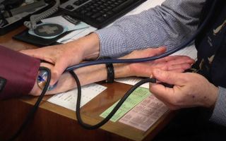 Close up of doctor taking patient's pulse using stethoscope