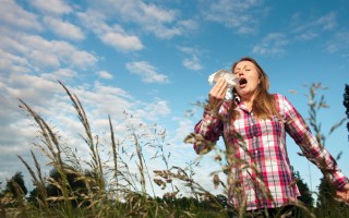 Woman sneezing in tall grass