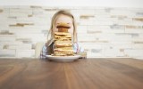 child sitting behind a stack of baked goods