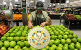 A Woolworths employee sorts apples with a coin superimposed on top.