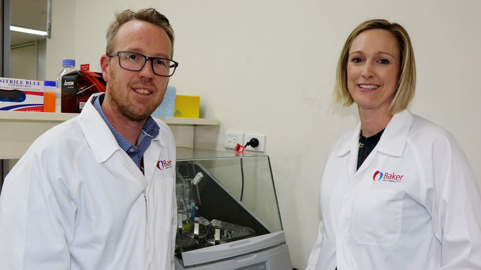Researchers standing in front of lab equipment at Baker Institute