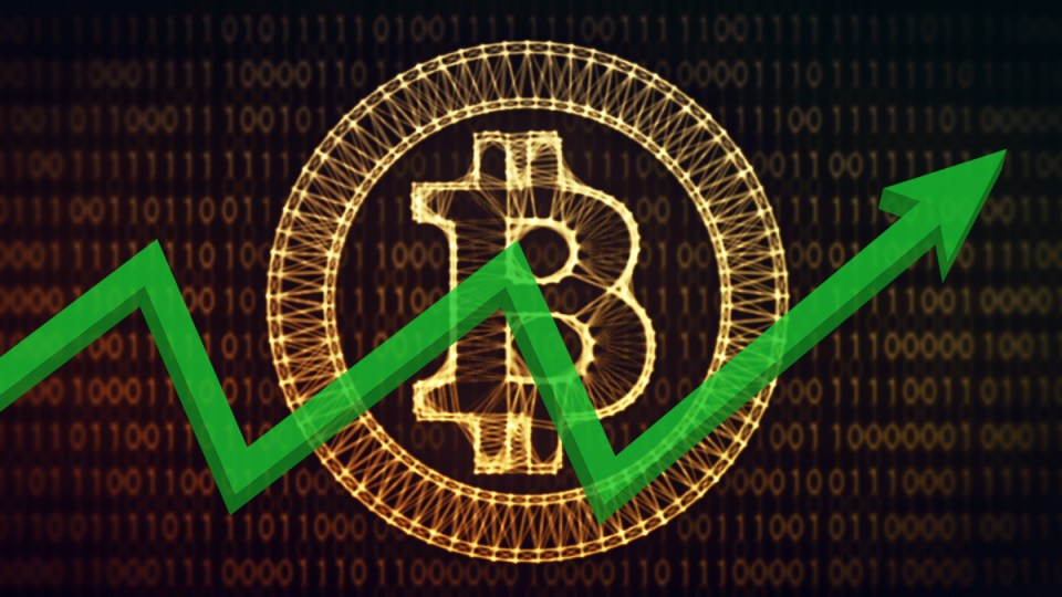 A bitcoin logo behind a graph.