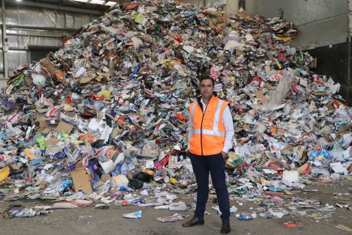 AWMA chief executive Adam Faulkner in front of a huge pile of recycling.