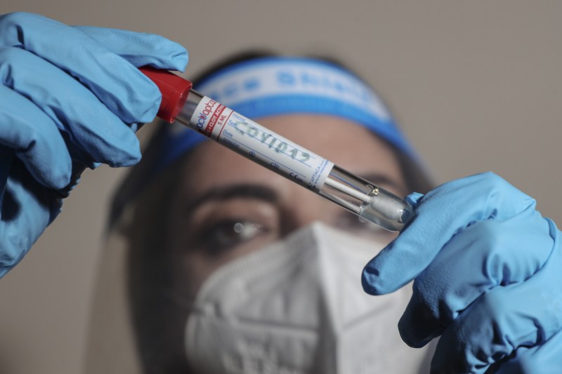 A doctor looks at a test tube