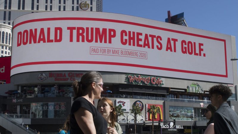 People walk past a billboard paid for by Democratic presidential hopeful Mike Bloomberg, that is attacking President Trump and is displayed on the iconic Las Vegas Strip, in Nevada, on February 21, 2020. Photo: Getty