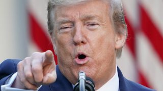 President Donald trump points to a reporter
