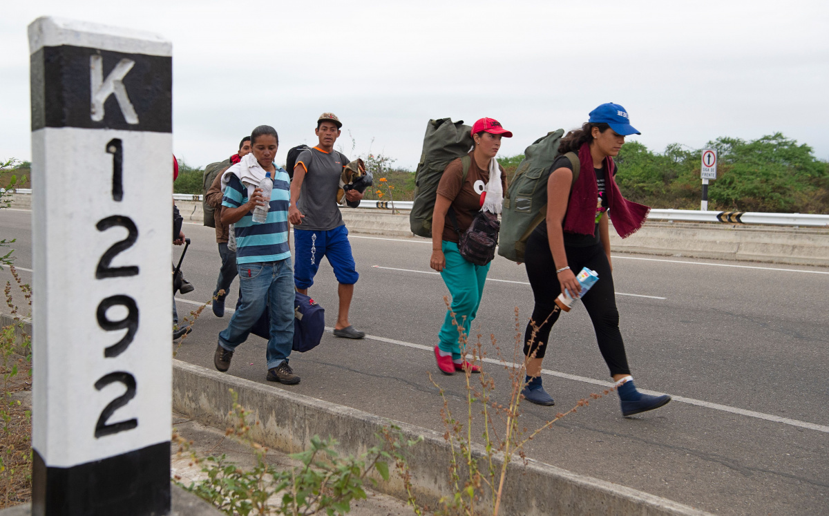 A group of Venezuelan migrants walk southbound along the Pan American highway after receiving their refugee permit. Photo: Getty