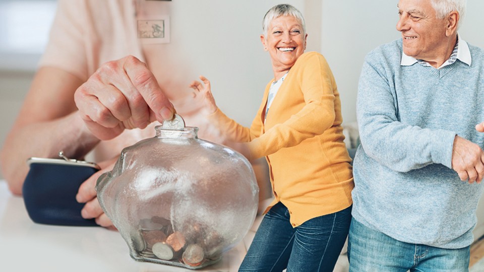 Older couple celebrating while putting money in a jar.