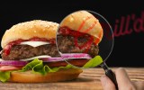 A grill'd burgerbeing investigated by a magnifying glass.