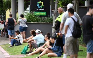 People are seen in long queues outside the Centrelink office in Southport on the Gold Coast, Monday, March 23, 2020. Centrelink offices around Australia have been inundated with people attempting to register for JobSeeker.