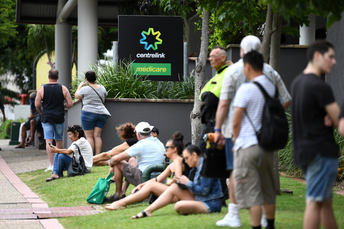 People are seen in long queues outside the Centrelink office in Southport on the Gold Coast, Monday, March 23, 2020. Centrelink offices around Australia have been inundated with people attempting to register for JobSeeker.