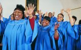 Twelve Gospel Singers With Raised Hands Singing in a Church Service - stock