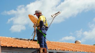 a satellite dish being installed on a roof