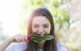 Portrait Of Young Woman Eating Leaf Vegetable