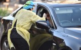 A medic takes a nasal swab from a driver at a drive-through testing centre for the COVID-19 coronavirus in Sydney