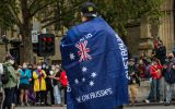 A man wearing a 'Proud Boys' shirt and an Australian flag attends the Invasion Day rally in the city on January 26, 2021 in Melbourne, Australia.