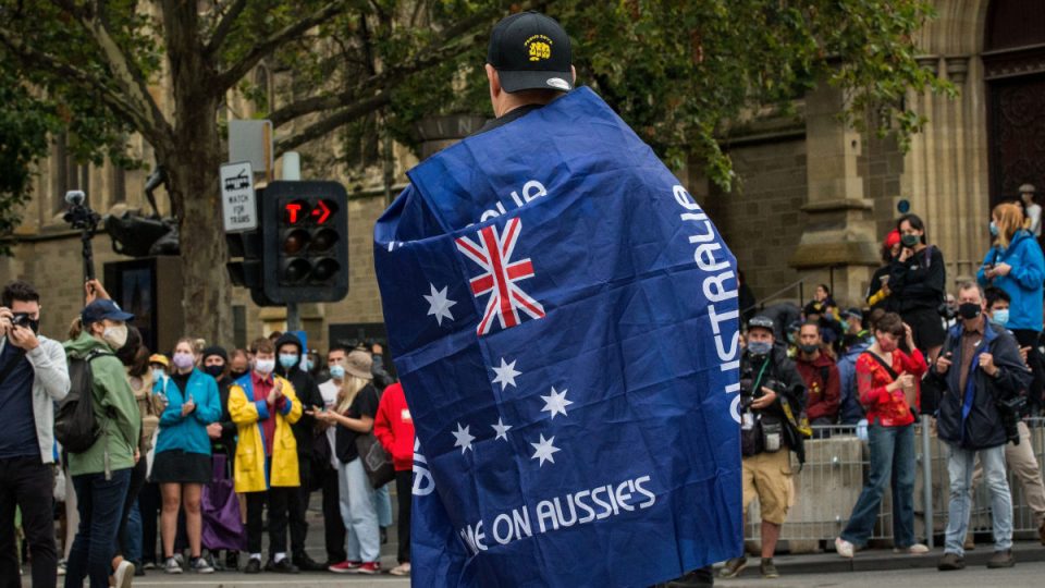 A man wearing a 'Proud Boys' shirt and an Australian flag attends the Invasion Day rally in the city on January 26, 2021 in Melbourne, Australia.