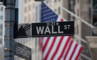 sign for Wall Street and American flags in New York, U.S