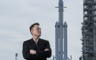 Elon Musk poses with the SpaceX Falcon Heavy rocket, NASA's Kennedy Space Center in Cape Canaveral, Fla., Feb. 5, 2018. By inserting himself into the confounding GameStop stock market drama, Musk has solidified his role as the ultimate insider outsider.