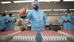 Scott Morrison holds a vial of the AstraZeneca vaccine at the CSL serum lab in Melbourne.