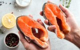 Hands holding raw salmon steaks
