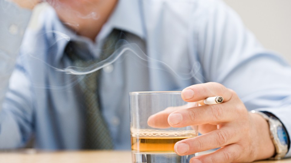 Man drinking whisky and smoking